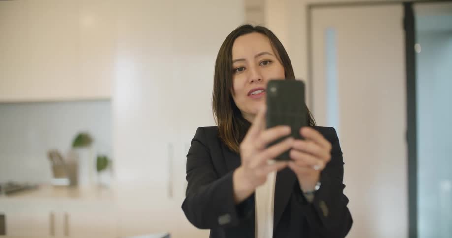 A woman walks through the room talking on her cellphone