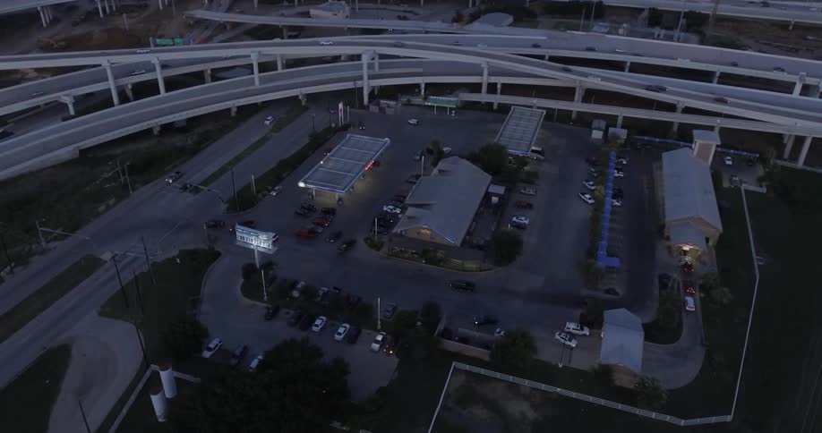Cars traverse a freeway interchange near a gas station