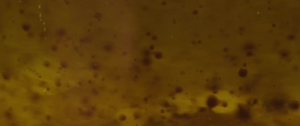 Small bubbles move in yellow liquid