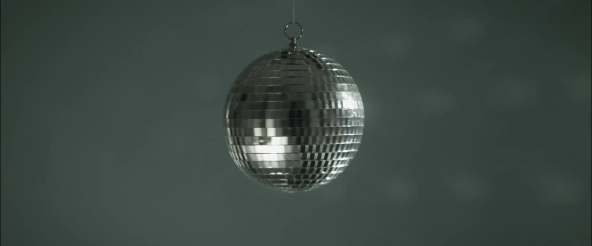 Silver globe spinning and reflecting light in a discotheque