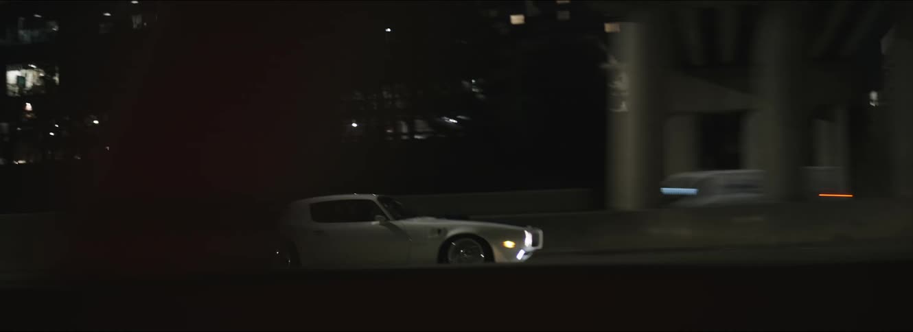 A car driving down city streets at night