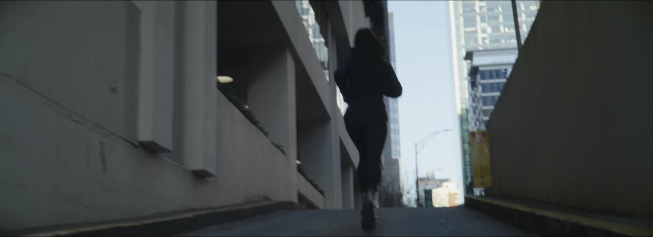 A woman jogs up the ramp towards the buildings