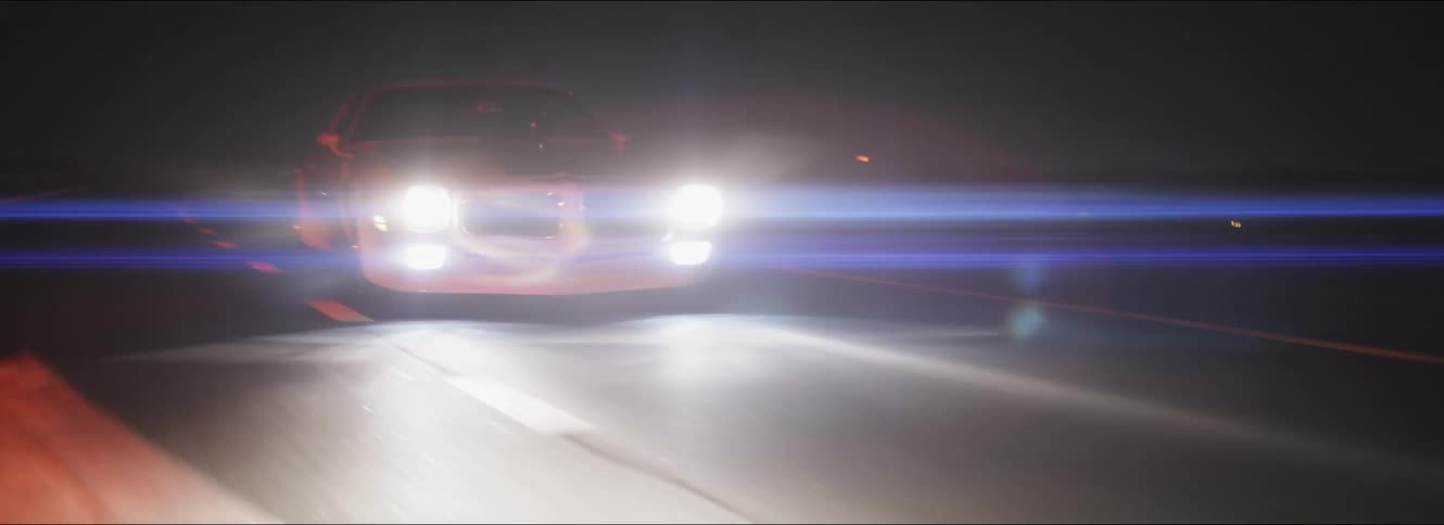 A car is racing on the highway at night