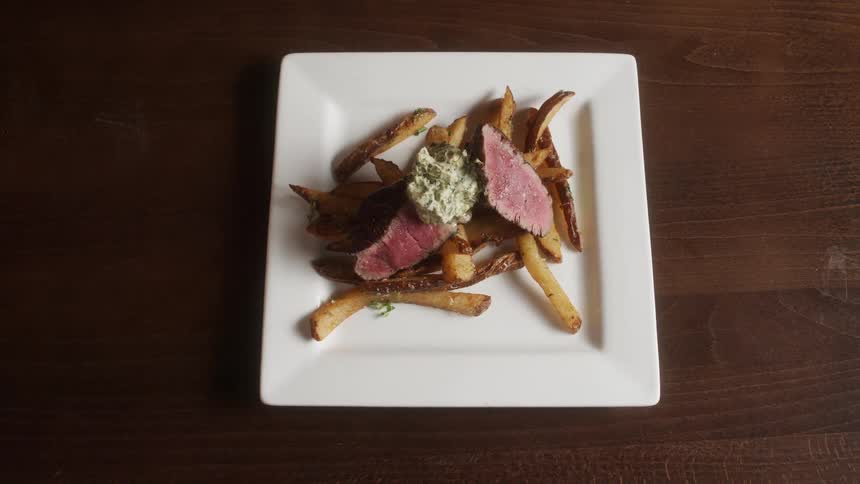 Medium rare steak with fries on plate