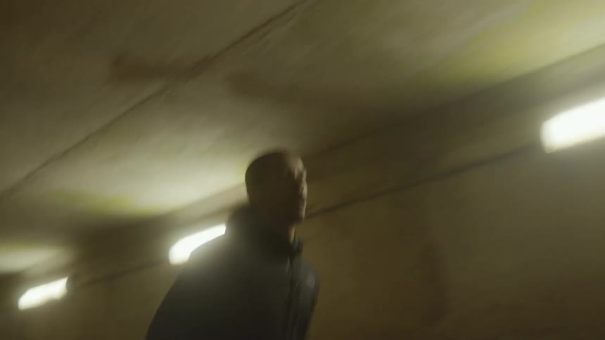 A man jogging through a dark tunnel at night