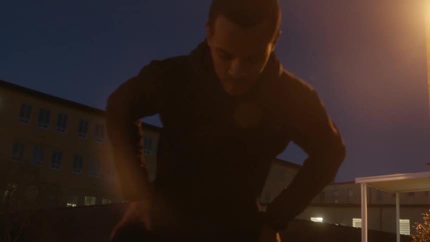 A man is stretching outside in front of the building