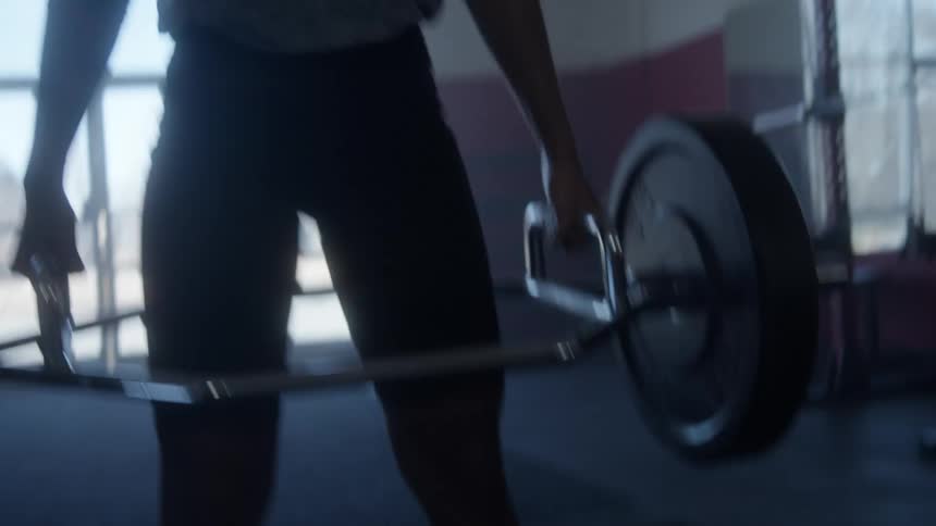 Woman with curly hair lifts weights in the gym