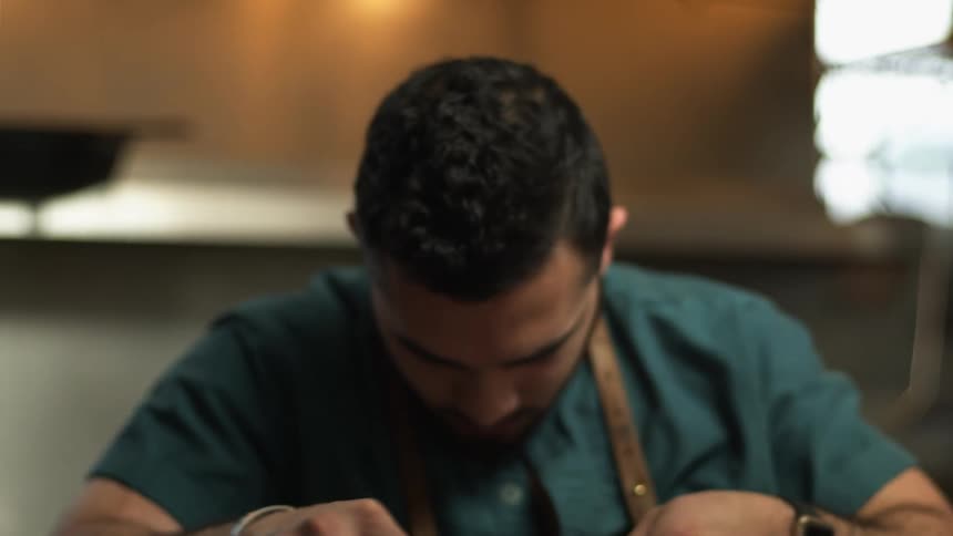 Chef grating cheese over a dish on the restaurant kitchen