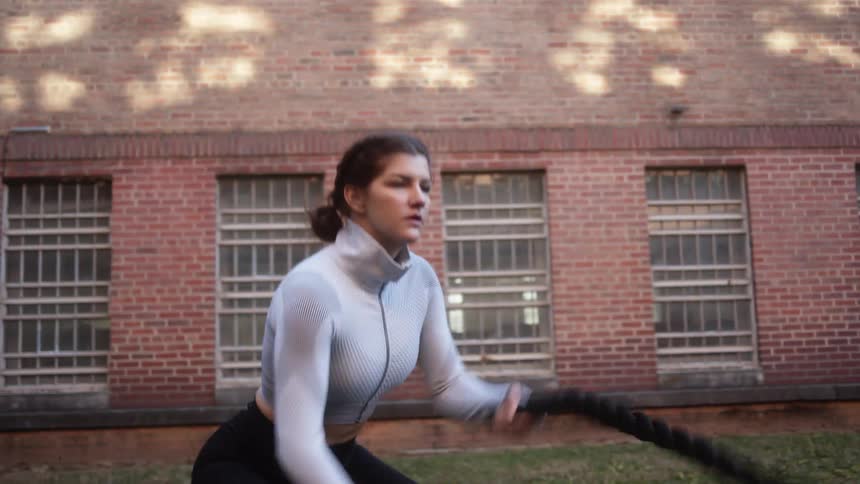 A woman exercising with ropes outdoors