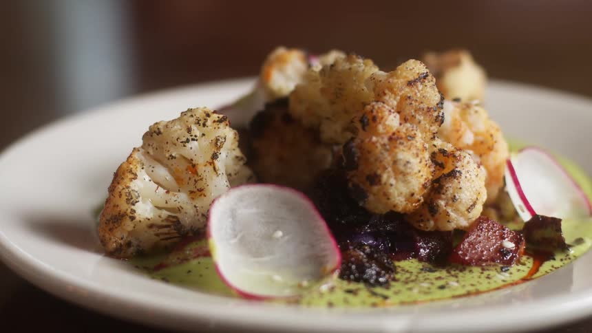 Close up of a small dish with food over a wooden table
