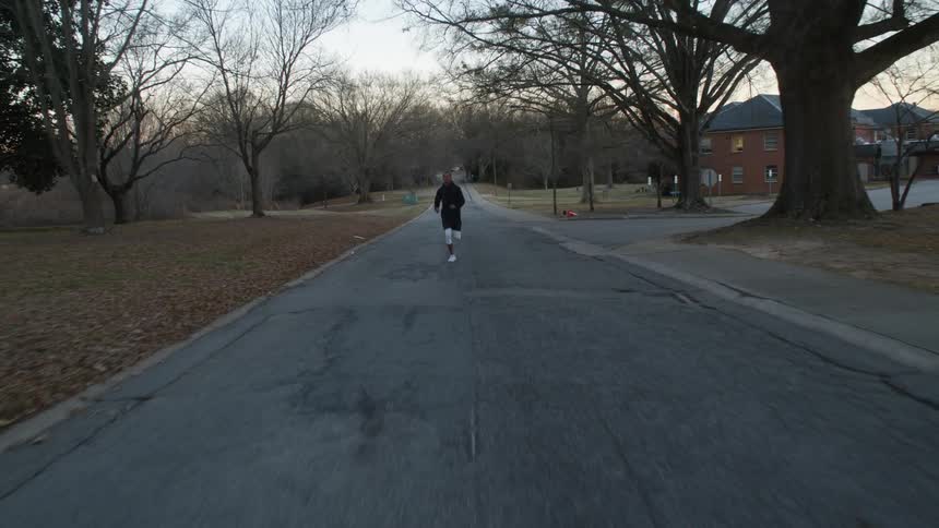 A man running down a street in a neighborhood