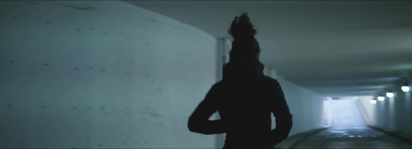Young woman wearing sports clothes starts jogging on a parking garage