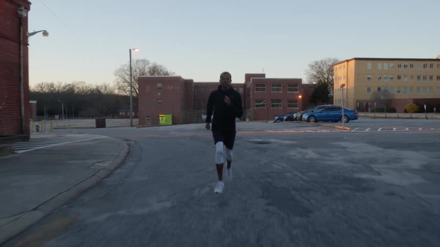 A man is running through the parking lot