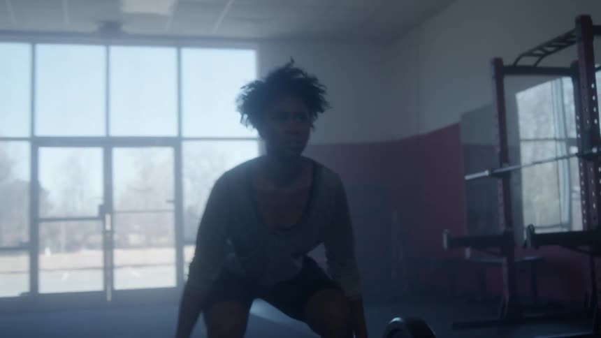 A woman is lifting weights in the gym