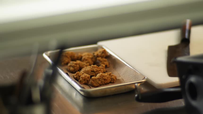 Fried fries on plate next to cleaver in restaurant