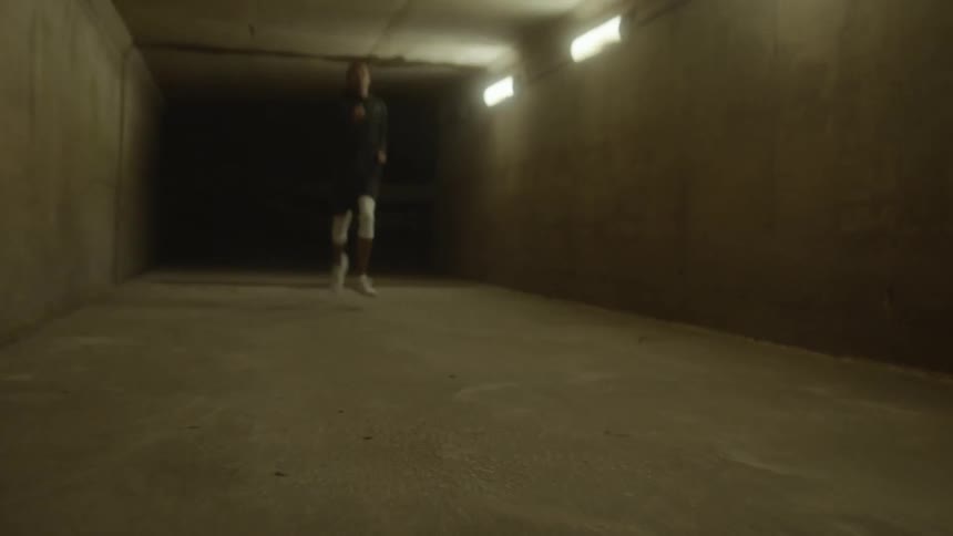 A man jogging through a dark tunnel at night