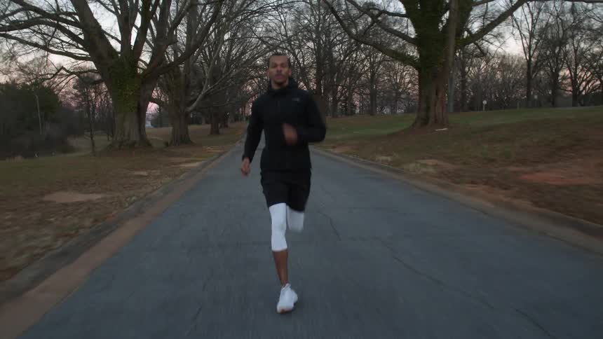 A man is running on the path through the park