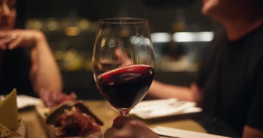 A man is very animated as he talks to a table of people in a restaurant