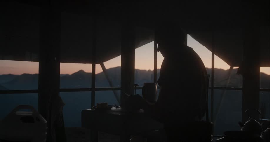 A silhouette of a person in a room with a window in the background