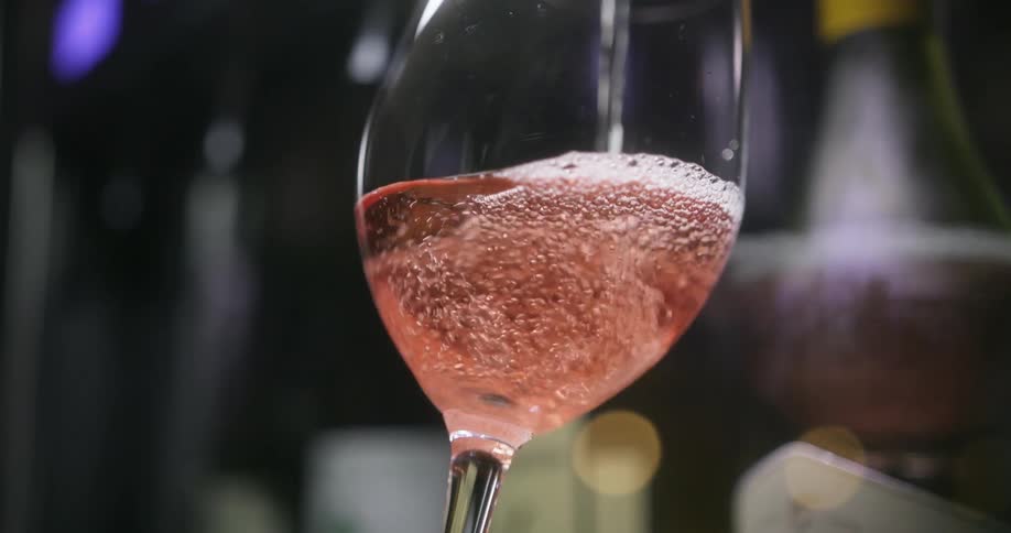 Champagne fills a glass and bubbles rise to the top