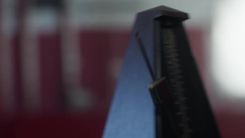 Metronome arm swings back and forth indicating timing