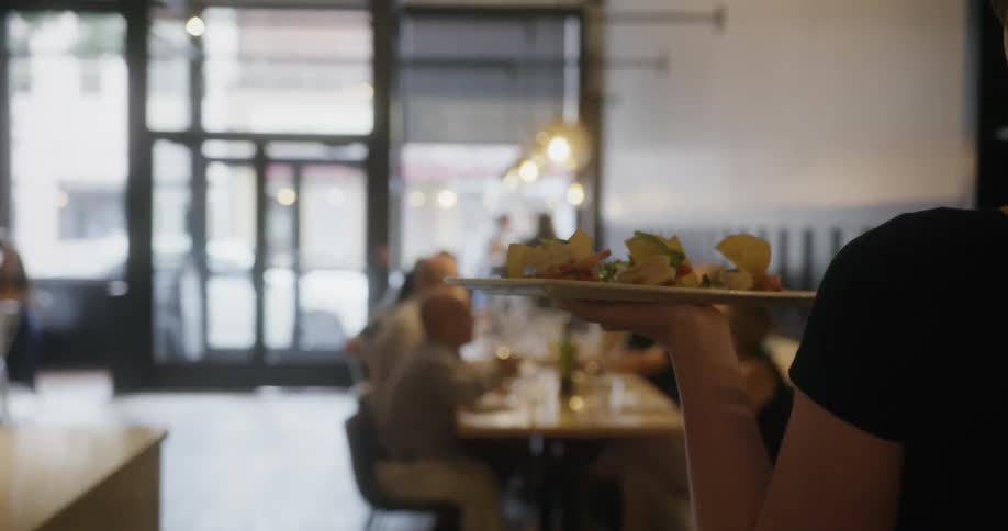 A waitress brings food out to a full restuarant