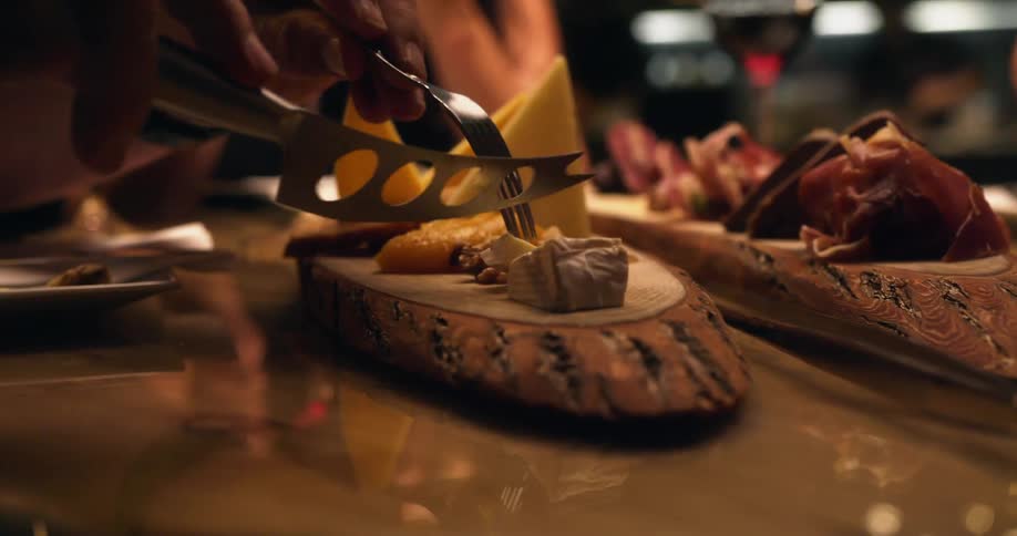 People eating cheese from a charcuterie table on a restaurant