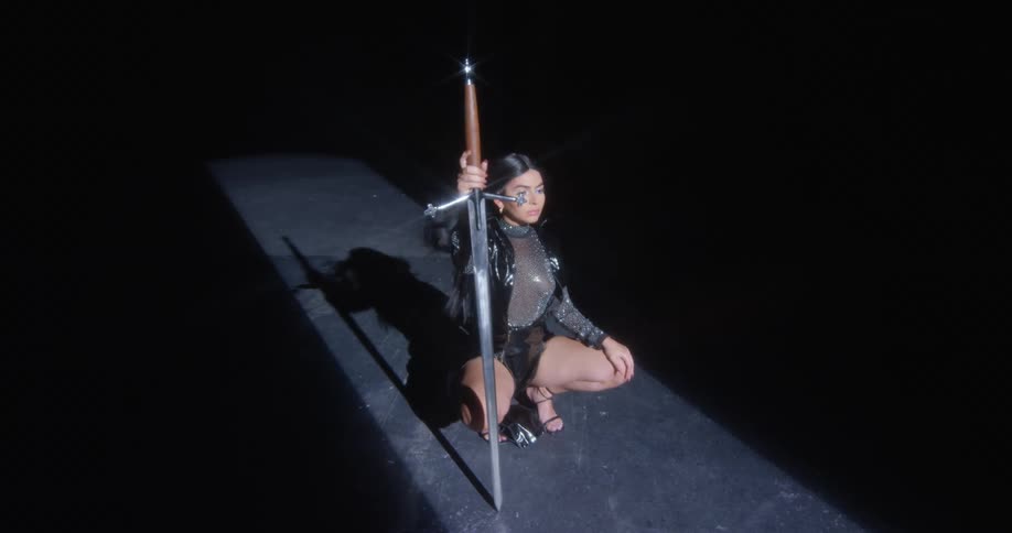 A woman in a room holding a sword