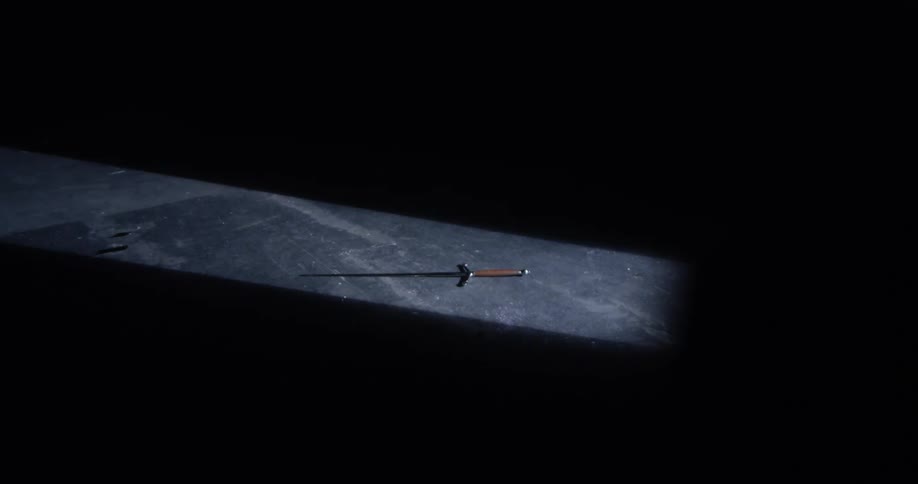 A sword lying on the ground in darkness