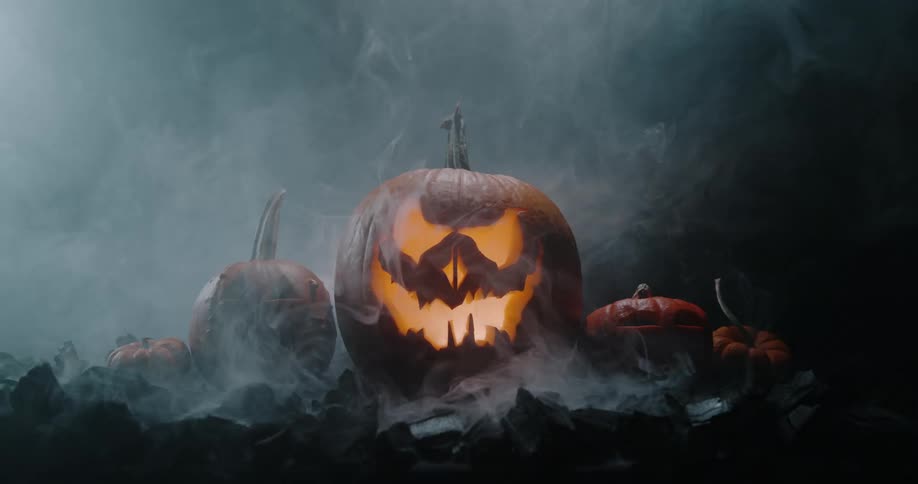 Light flashes across group of carved pumpkins one jack olantern glowing from within