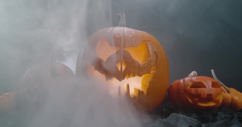 Jack o lanterns are positioned together with smoke rising from underneath them