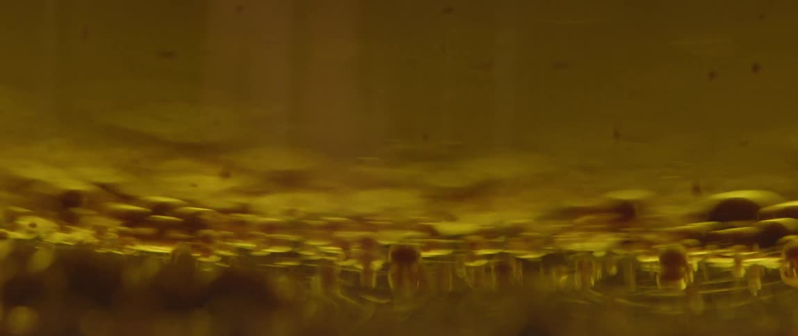 Abstract liquid comes in and out of focus as something passes the camera