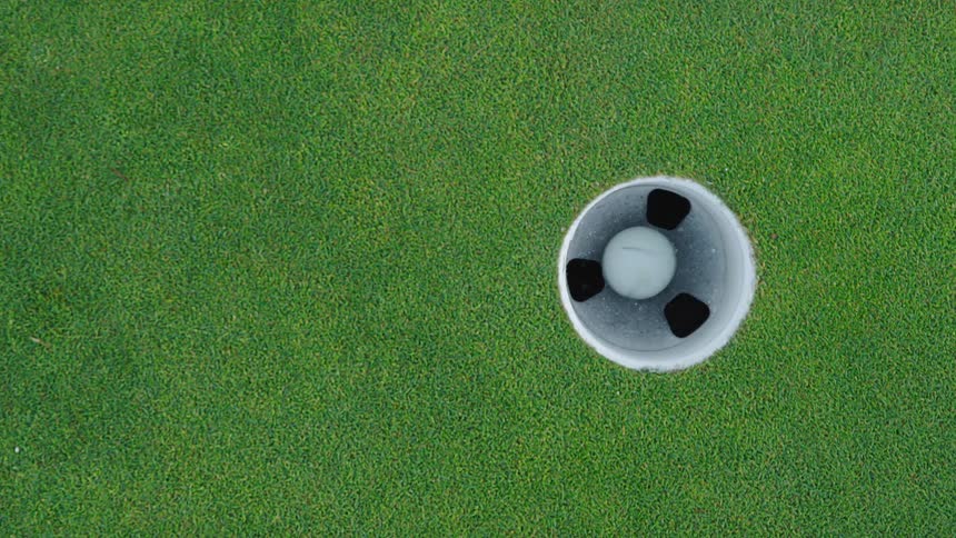 Golf ball is being hit into hole