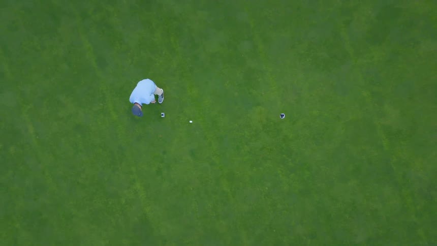 A golfer tees up and hits a hole in one