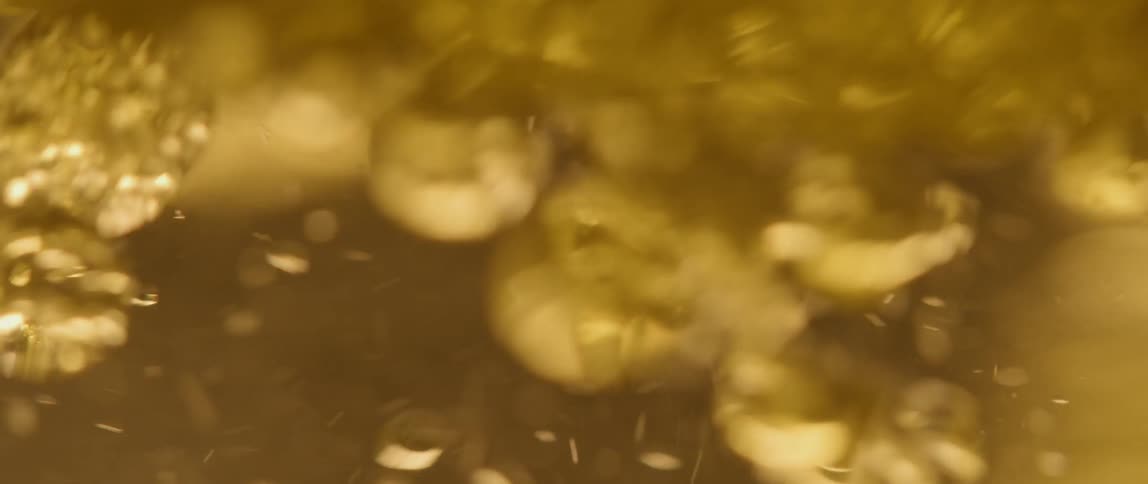 Bubbles swirling in yellow liquid