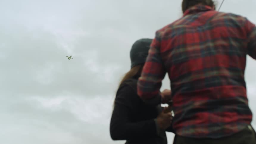 A man is showing a woman how to do something outside
