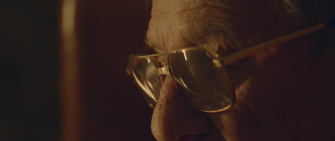 A reflection in an older man's eyeglasses