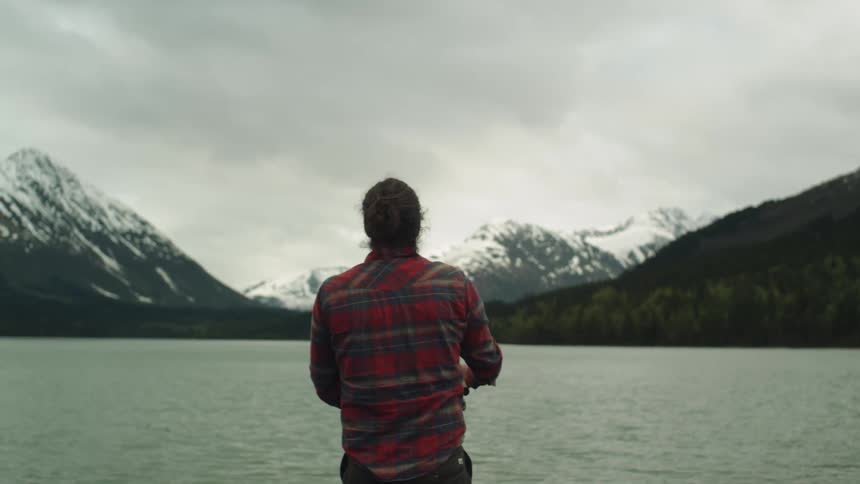A man casts his fishing pole in the lake