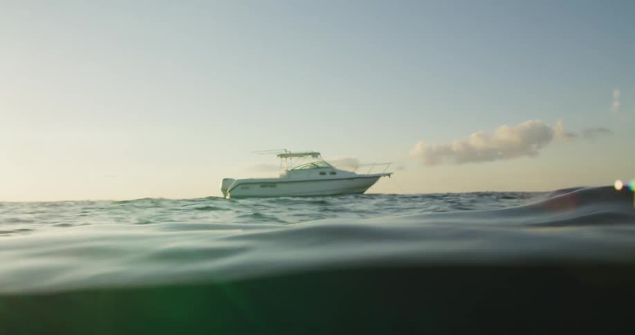 Boat travels on water at sunset