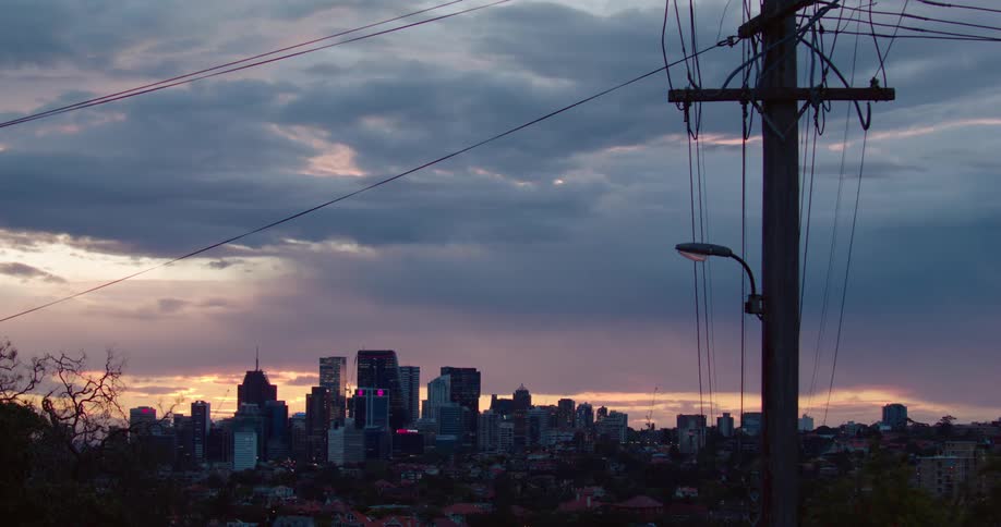 The skyline of a metropolis under a cloudy sky at sunset