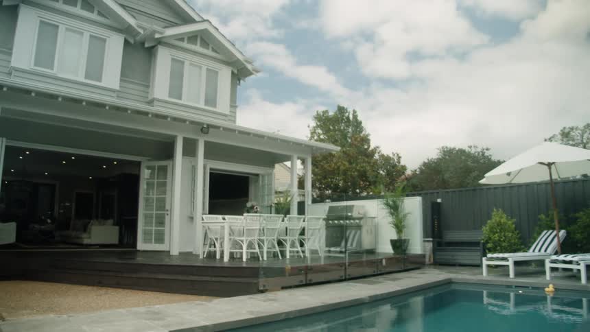 Exterior view of house with porch and swimming pool in the garden