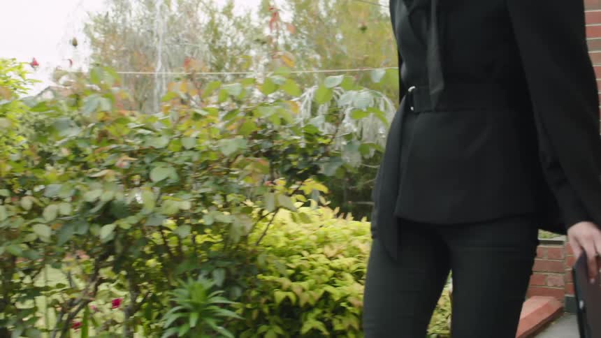 A woman rings an auction bell as she walks from one building to another