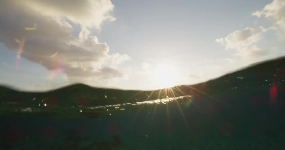 Waves roll on the ocean under a partly sunny sky