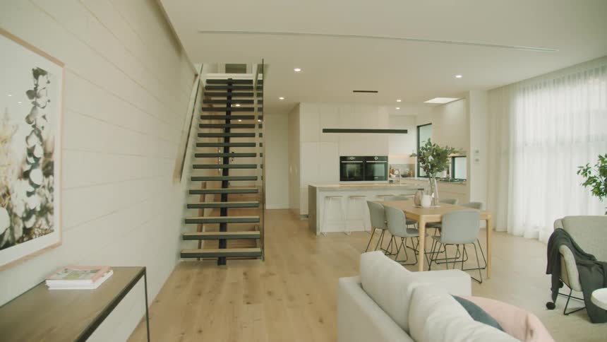 An open concept room has the kitchen and living room laid out galley style