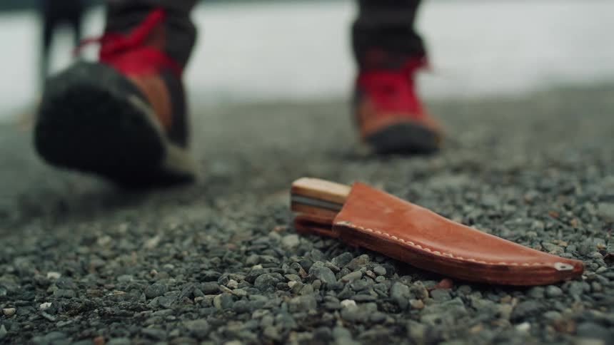 A person taking a fishing hook from the ground
