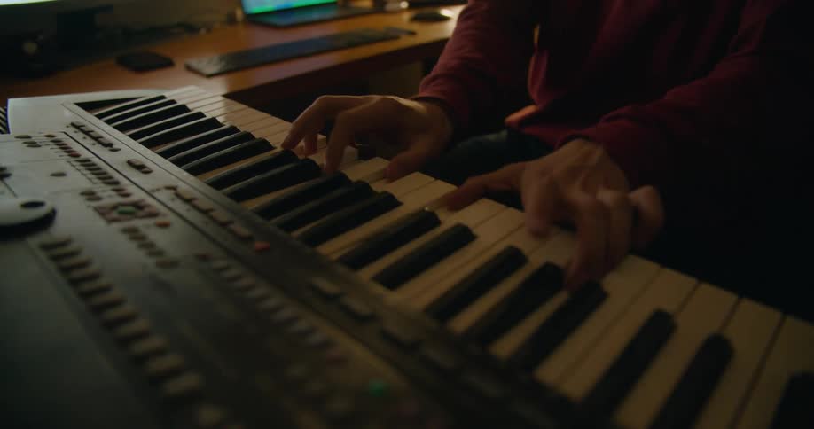 A person playing a piano in a room