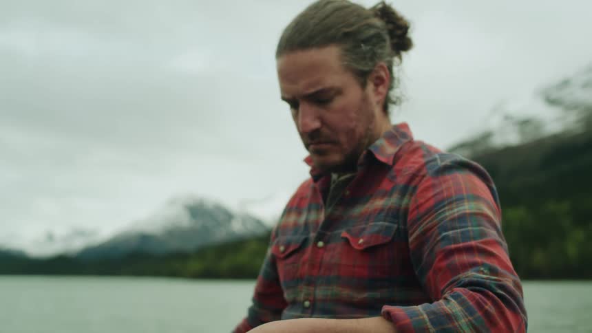 A man pulls the fishing line near the lake