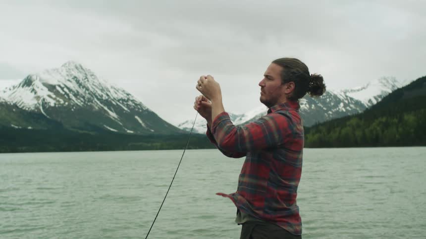 A man fishing outdoors at a lake