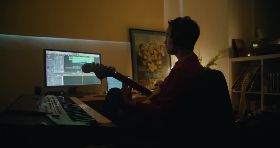 Musician playing electric guitar on his home studio