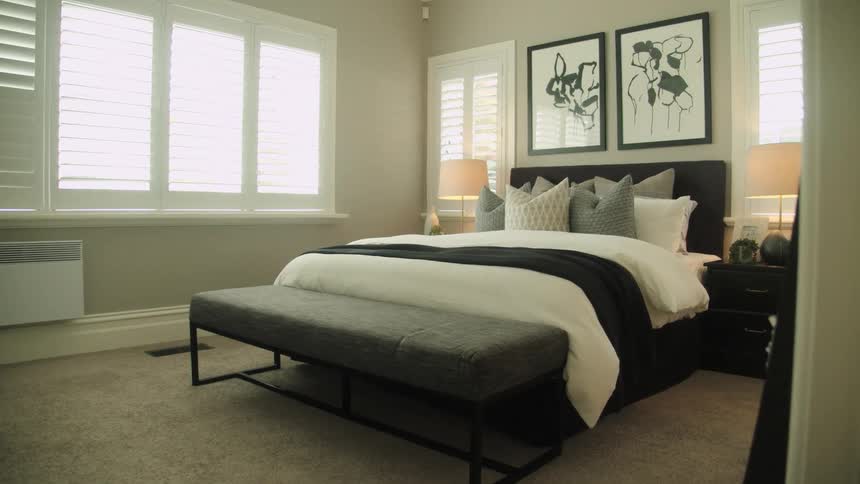 Entering a clean decorated bedroom with black and white artwork above the bed